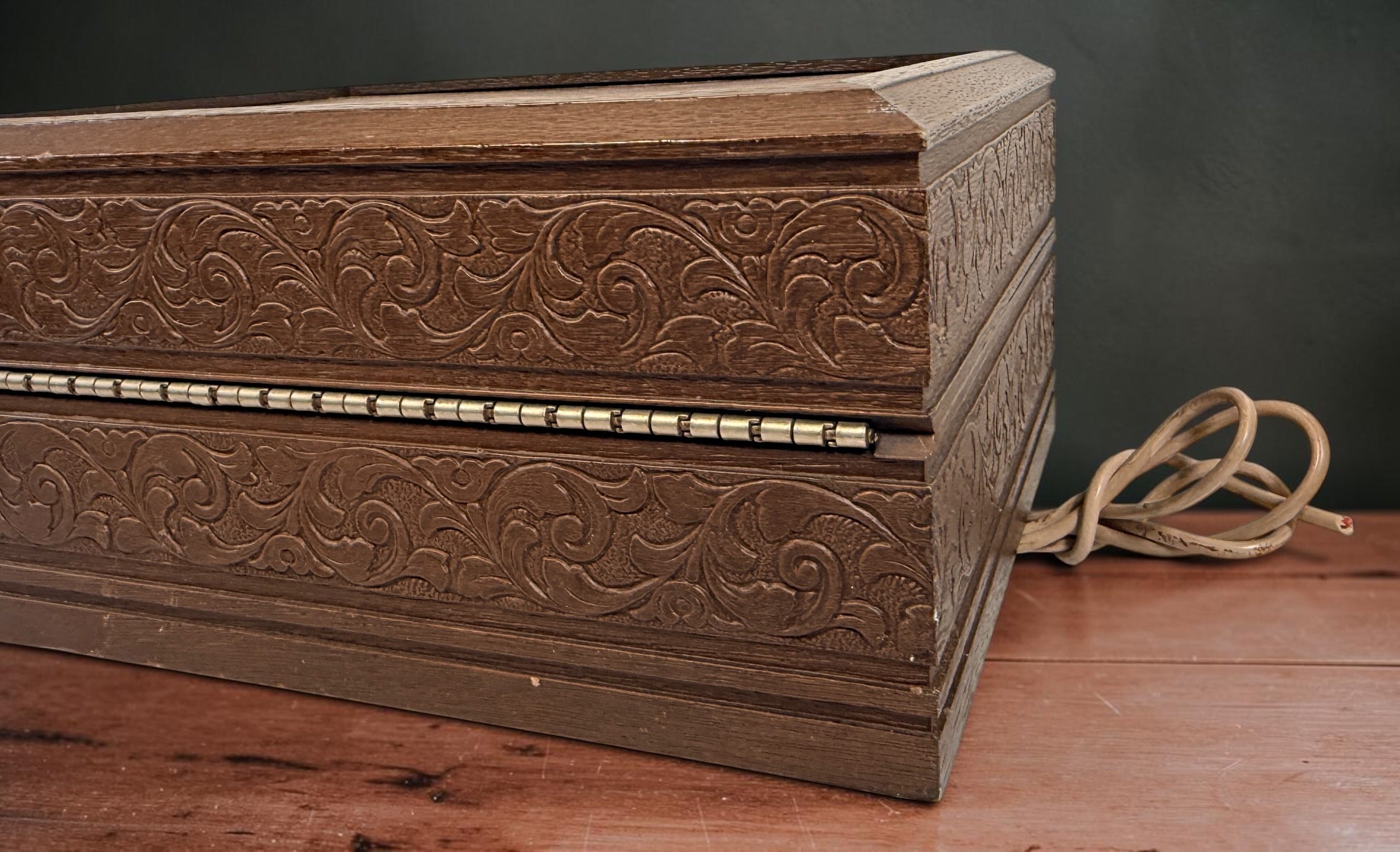 Vintage 1970s Deco-Tel rotary telephone hidden inside a decorative carved-look wood chest. Untested with cut line cord; sold as-is.