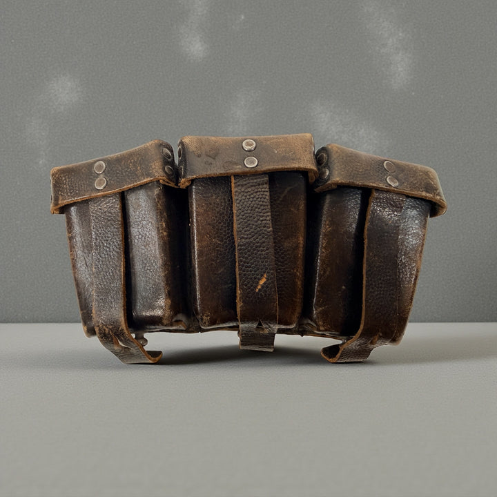 WWI German triple leather ammo pouch with pebbled finish. Early 1900s militaria, fair condition. Collectible display piece for reenactors and collectors.