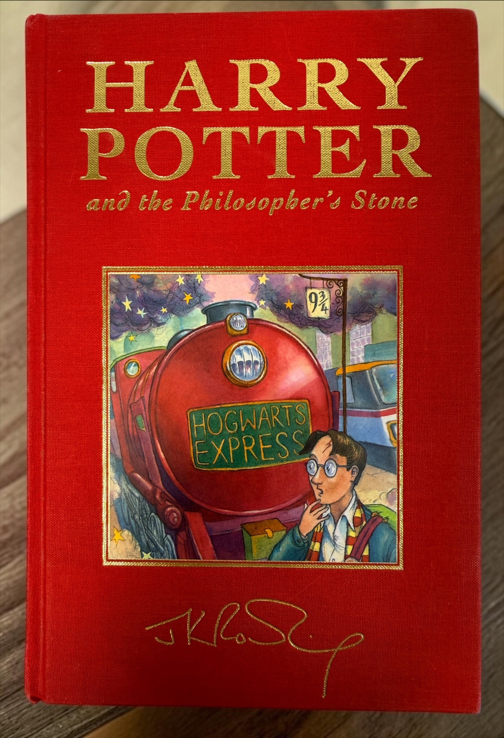 Collectible 1999 Harry Potter Philosopher’s Stone UK deluxe third printing with red cloth binding, gilt page edges and ribbon marker.