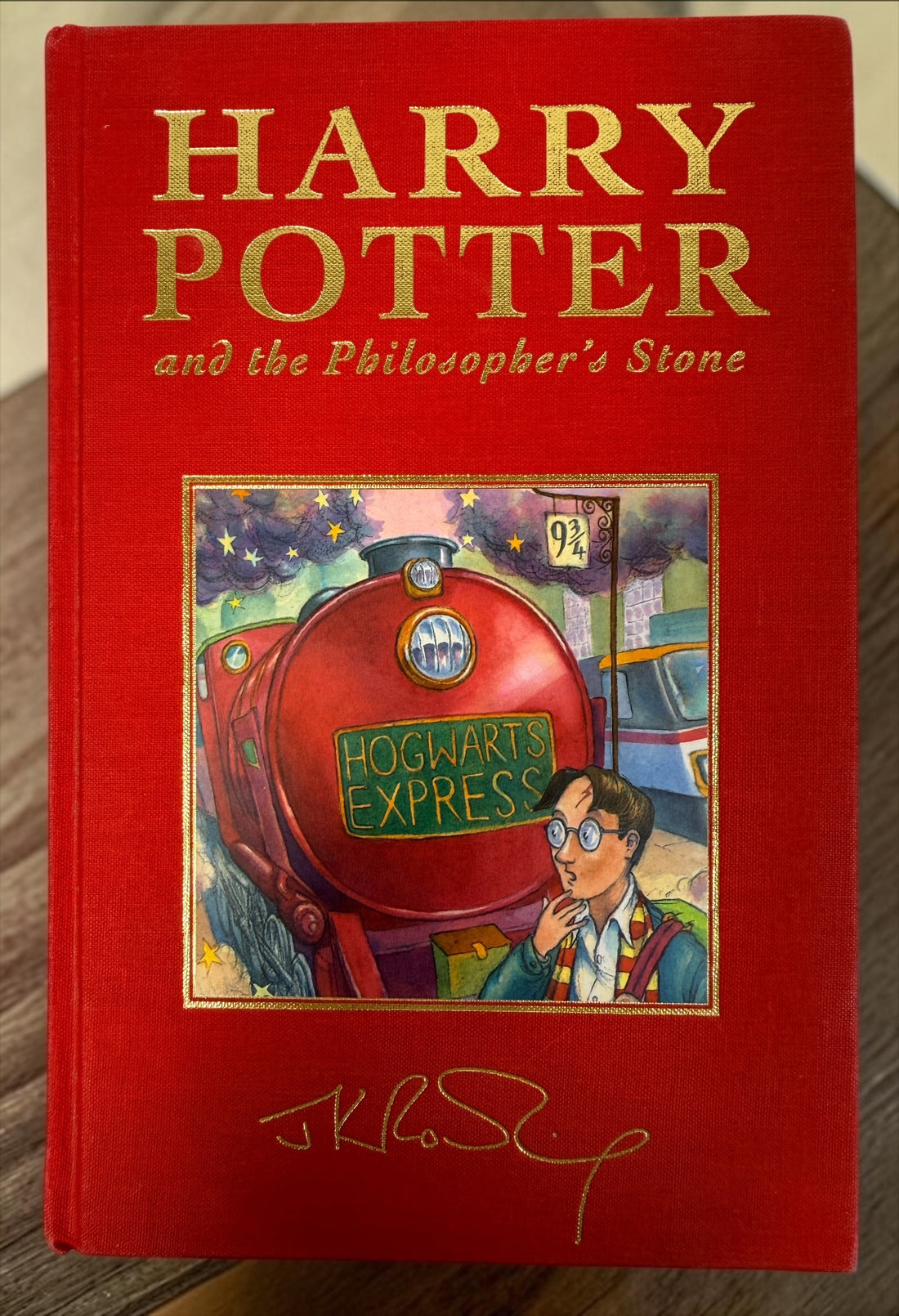 Collectible 1999 Harry Potter Philosopher’s Stone UK deluxe third printing with red cloth binding, gilt page edges and ribbon marker.