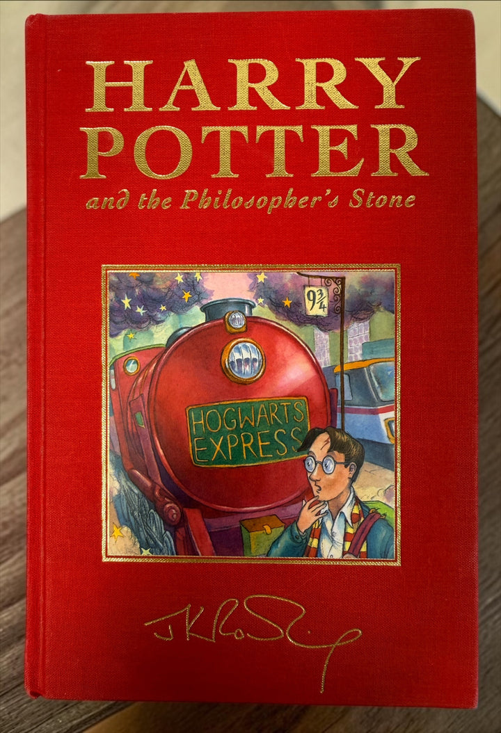 Collectible 1999 Harry Potter Philosopher’s Stone UK deluxe third printing with red cloth binding, gilt page edges and ribbon marker.