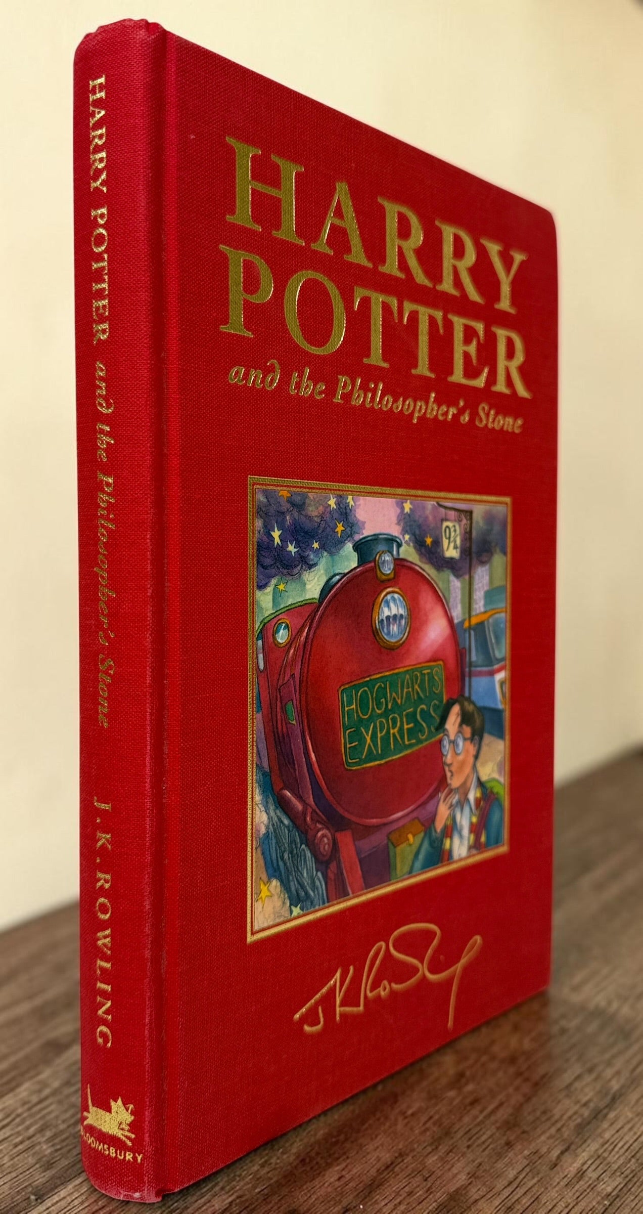 Collectible 1999 Harry Potter Philosopher’s Stone UK deluxe third printing with red cloth binding, gilt page edges and ribbon marker.