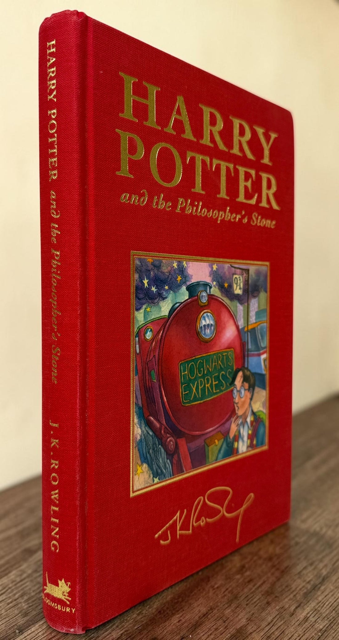 Collectible 1999 Harry Potter Philosopher’s Stone UK deluxe third printing with red cloth binding, gilt page edges and ribbon marker.
