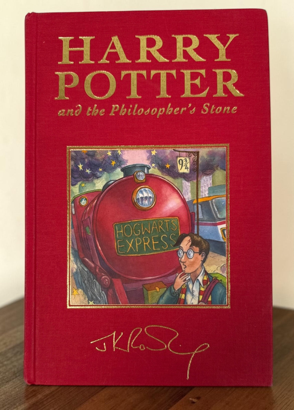 Collectible 1999 Harry Potter Philosopher’s Stone UK deluxe third printing with red cloth binding, gilt page edges and ribbon marker.