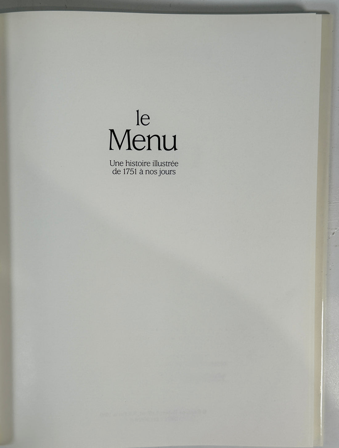 White menu cover with black text 'le Menu' on a white background