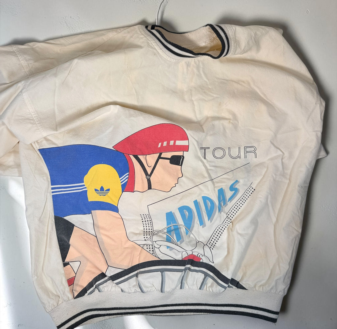 Vintage 80s Adidas cycling pullover in L/XL with bold cyclist graphics and CYCLING back print. 100% cotton. Vintage condition with visible stains.