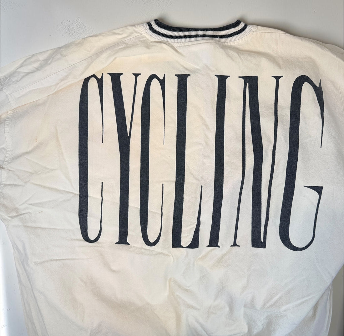 Vintage 80s Adidas cycling pullover in L/XL with bold cyclist graphics and CYCLING back print. 100% cotton. Vintage condition with visible stains.