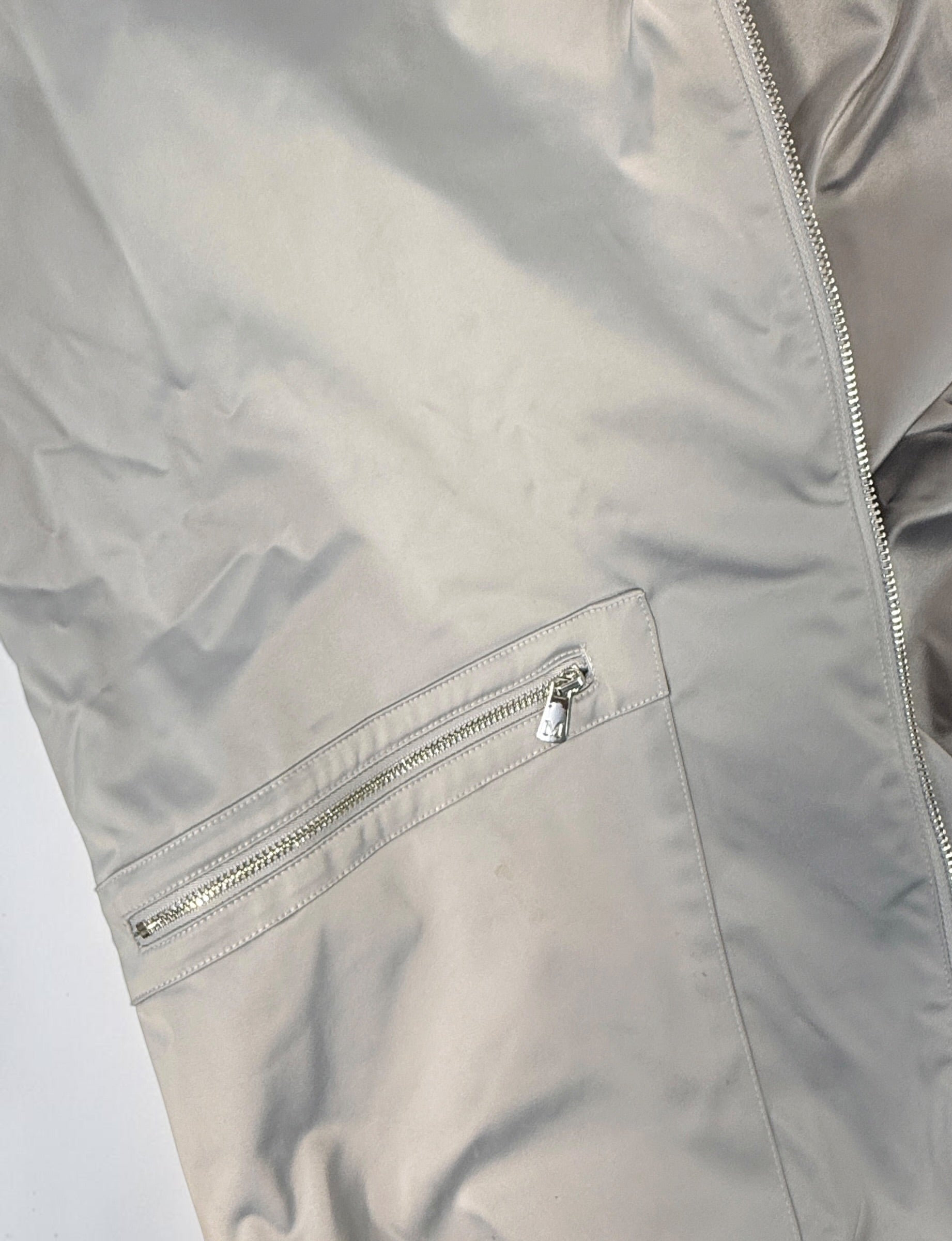Shop the Marciano Limitless bomber jacket in silver-grey satin, size M. Original tags attached, zip pockets and ribbed trim. Minor marks disclosed.