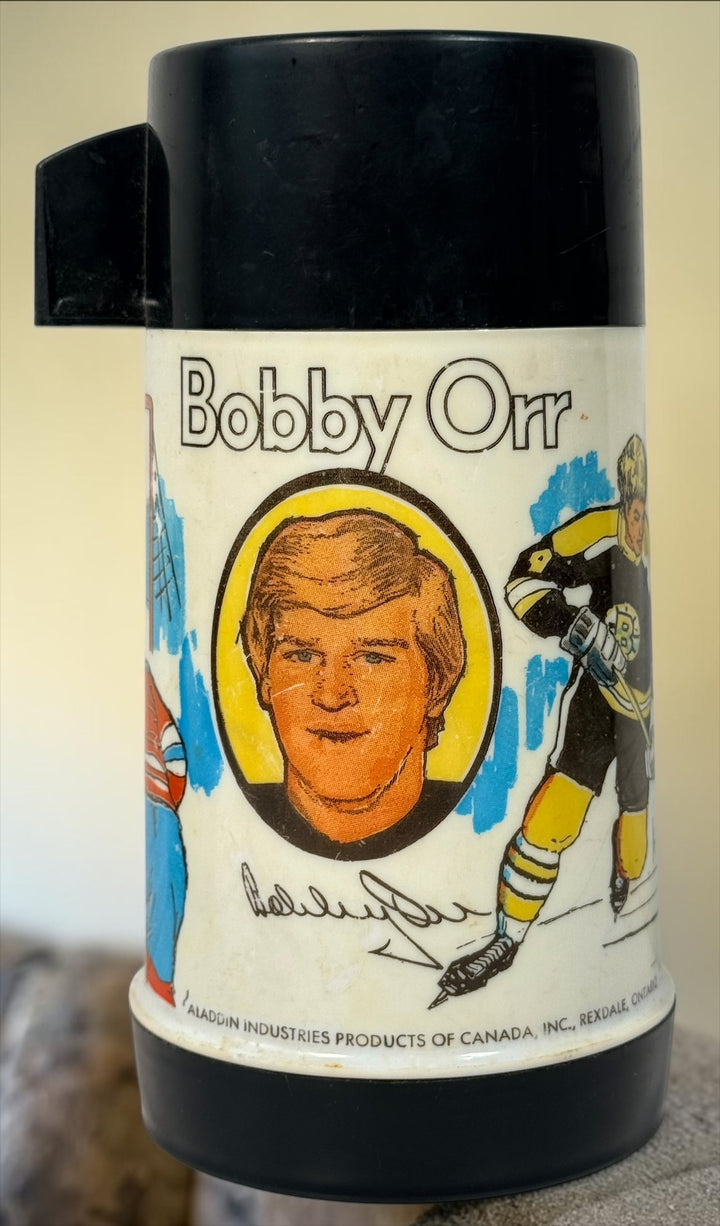 Vintage 1974 Bobby Orr Boston Bruins Aladdin thermos made in Canada with colourful hockey graphics, glass liner, stopper and original cup/lid.