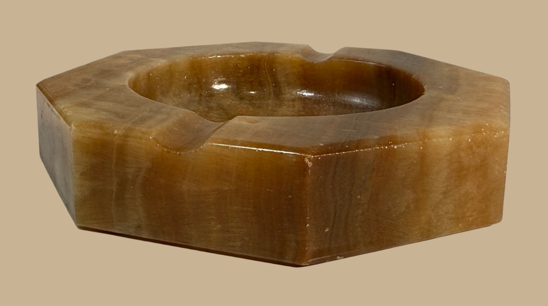 Brown stone ashtray on a white surface