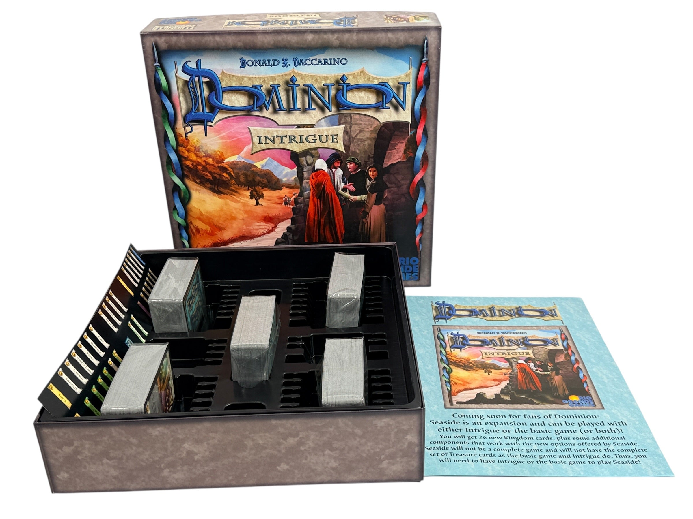 Early 2009 first edition Dominion Intrigue board game expansion. Partial sealed with original box. Classic deck-building strategy by Donald X. Vaccarino.