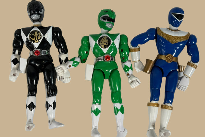 Three Power Ranger action figures in black, green, and blue on a white background