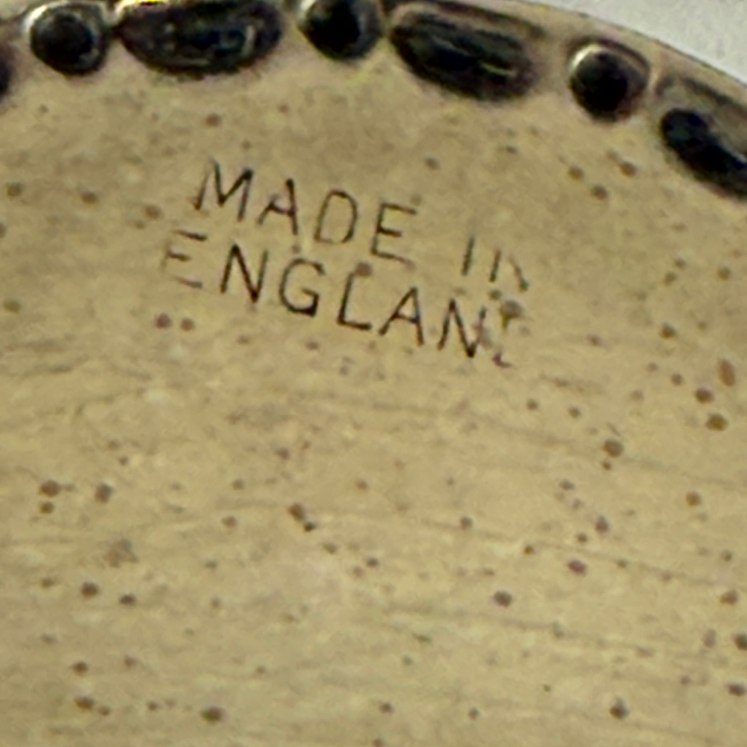 Close-up of a speckled ceramic plate with 'MADE IN ENGLAND' text.