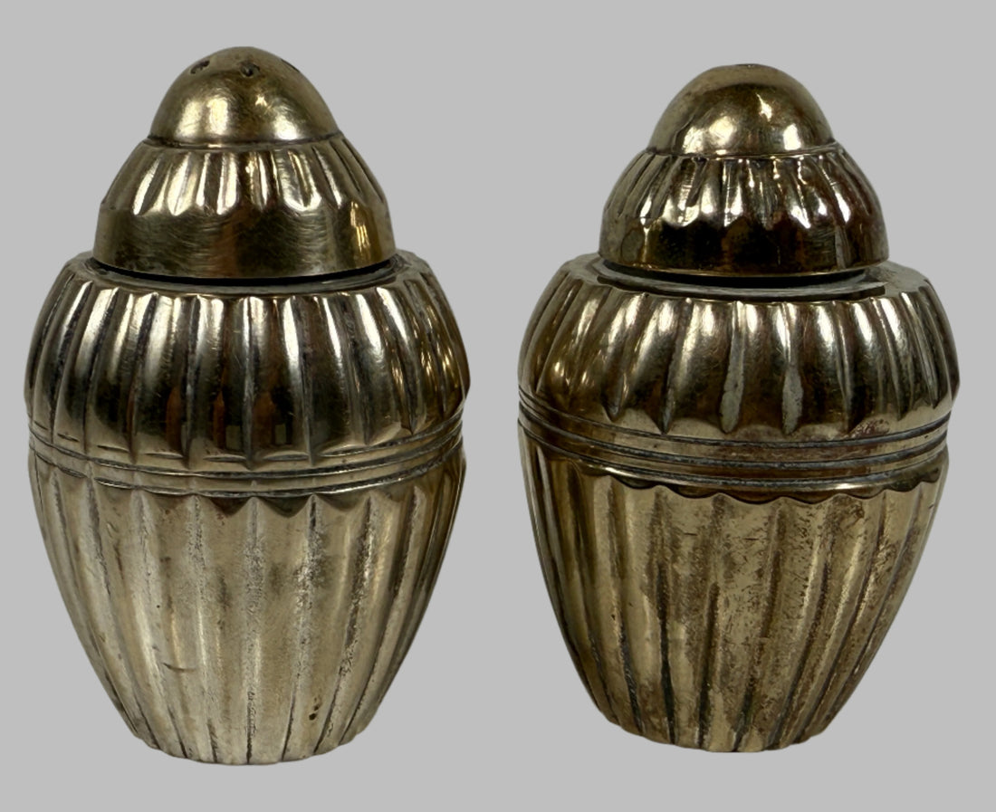 Two metallic acorn-shaped containers on a light gray background