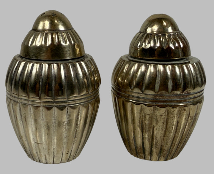 Two metallic acorn-shaped containers on a light gray background