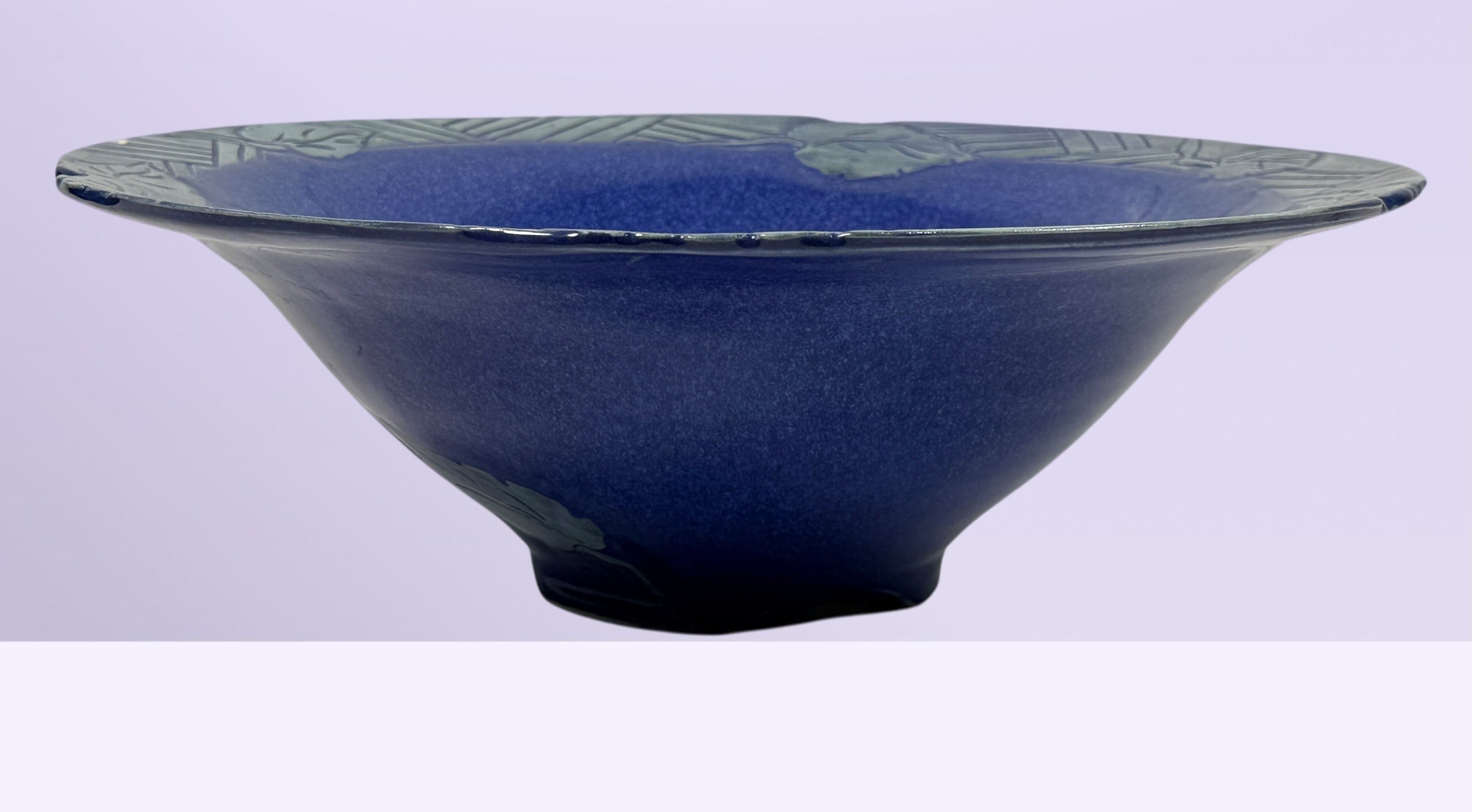 Signed studio pottery bowl with cobalt blue glaze and leaf rim detail. Handmade decorative ceramic centerpiece bowl ideal for modern rustic home decor.