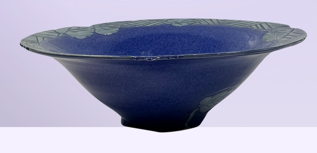 Signed studio pottery bowl with cobalt blue glaze and leaf rim detail. Handmade decorative ceramic centerpiece bowl ideal for modern rustic home decor.