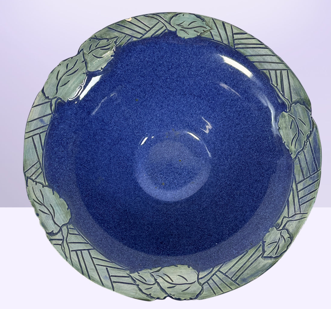 Signed studio pottery bowl with cobalt blue glaze and leaf rim detail. Handmade decorative ceramic centerpiece bowl ideal for modern rustic home decor.