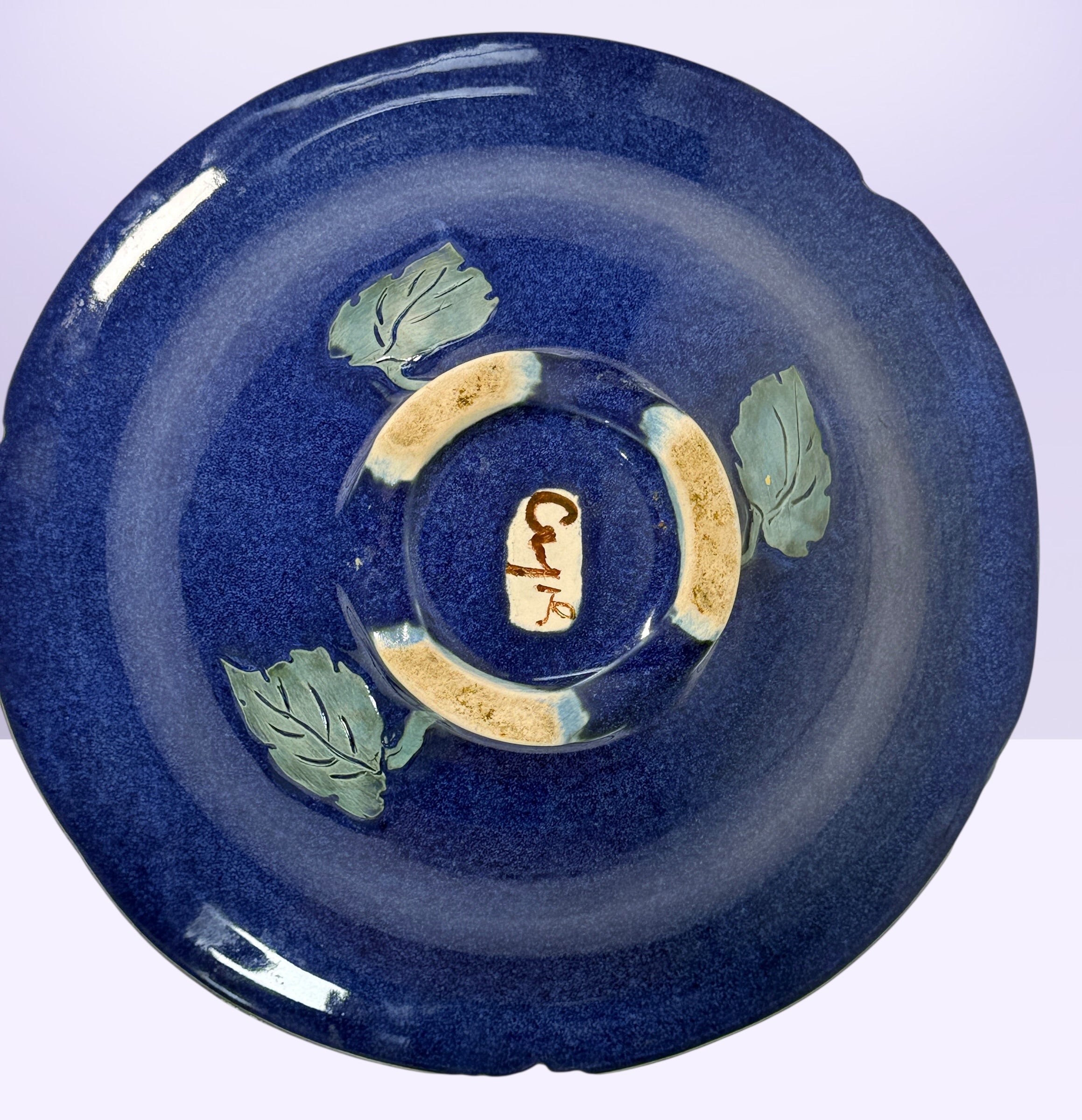 Signed studio pottery bowl with cobalt blue glaze and leaf rim detail. Handmade decorative ceramic centerpiece bowl ideal for modern rustic home decor.