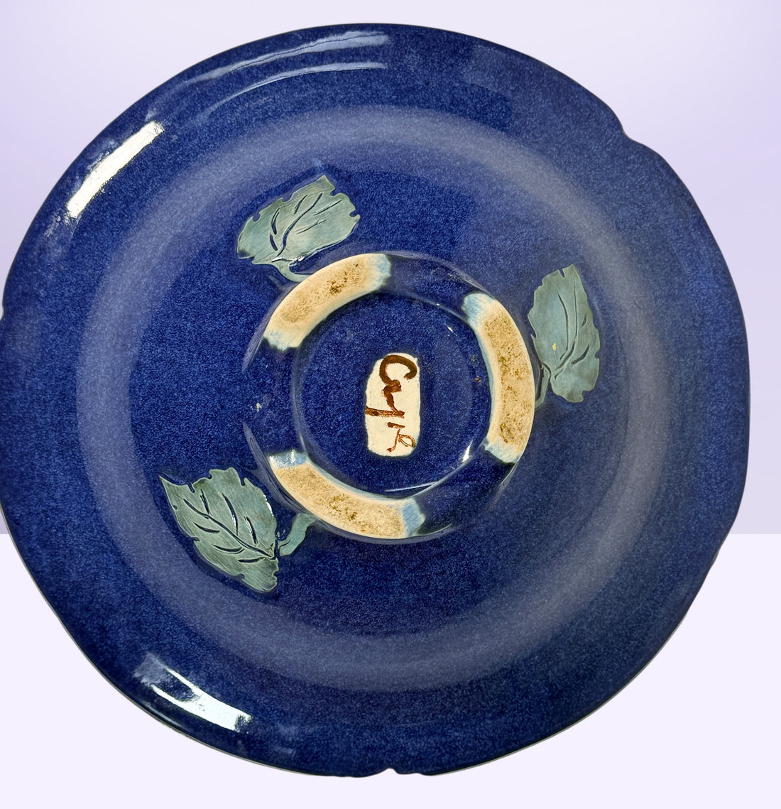 Signed studio pottery bowl with cobalt blue glaze and leaf rim detail. Handmade decorative ceramic centerpiece bowl ideal for modern rustic home decor.