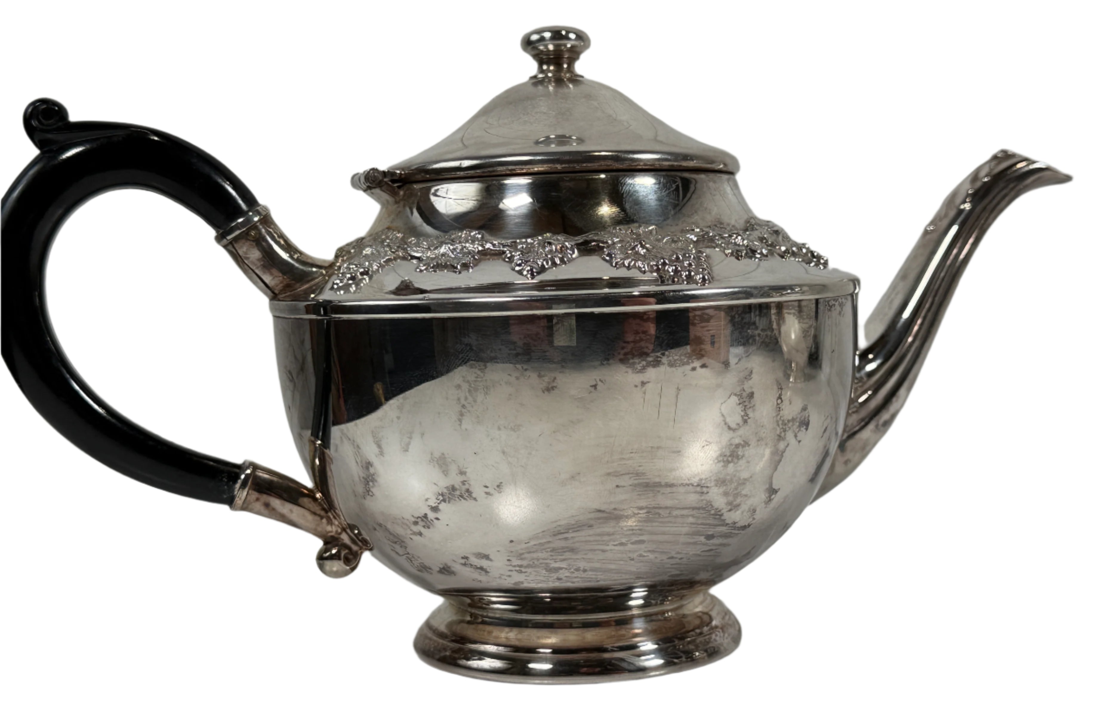 Silver teapot with black handle on a white surface