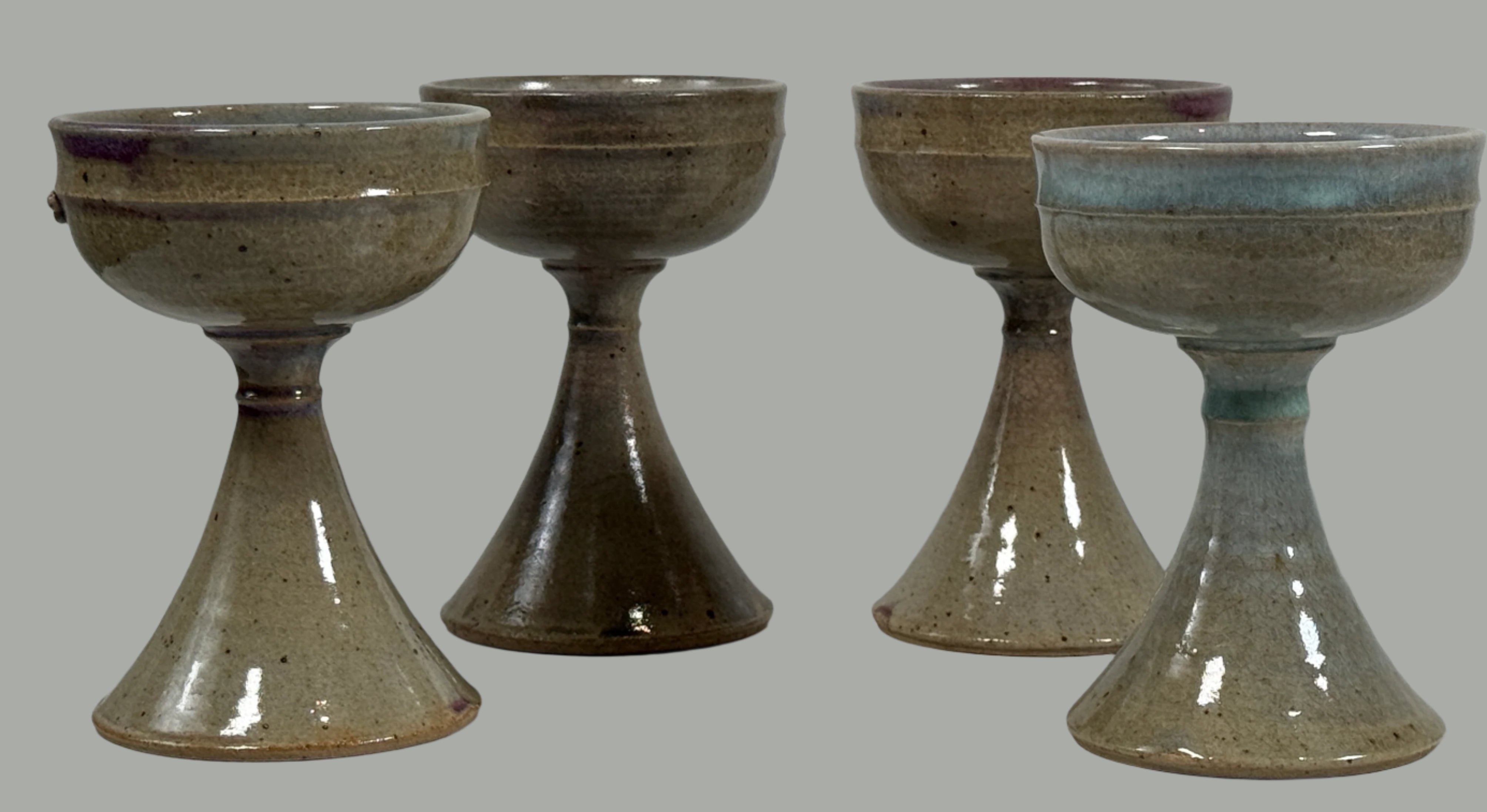 Four ceramic bowls with a textured finish on a white surface.