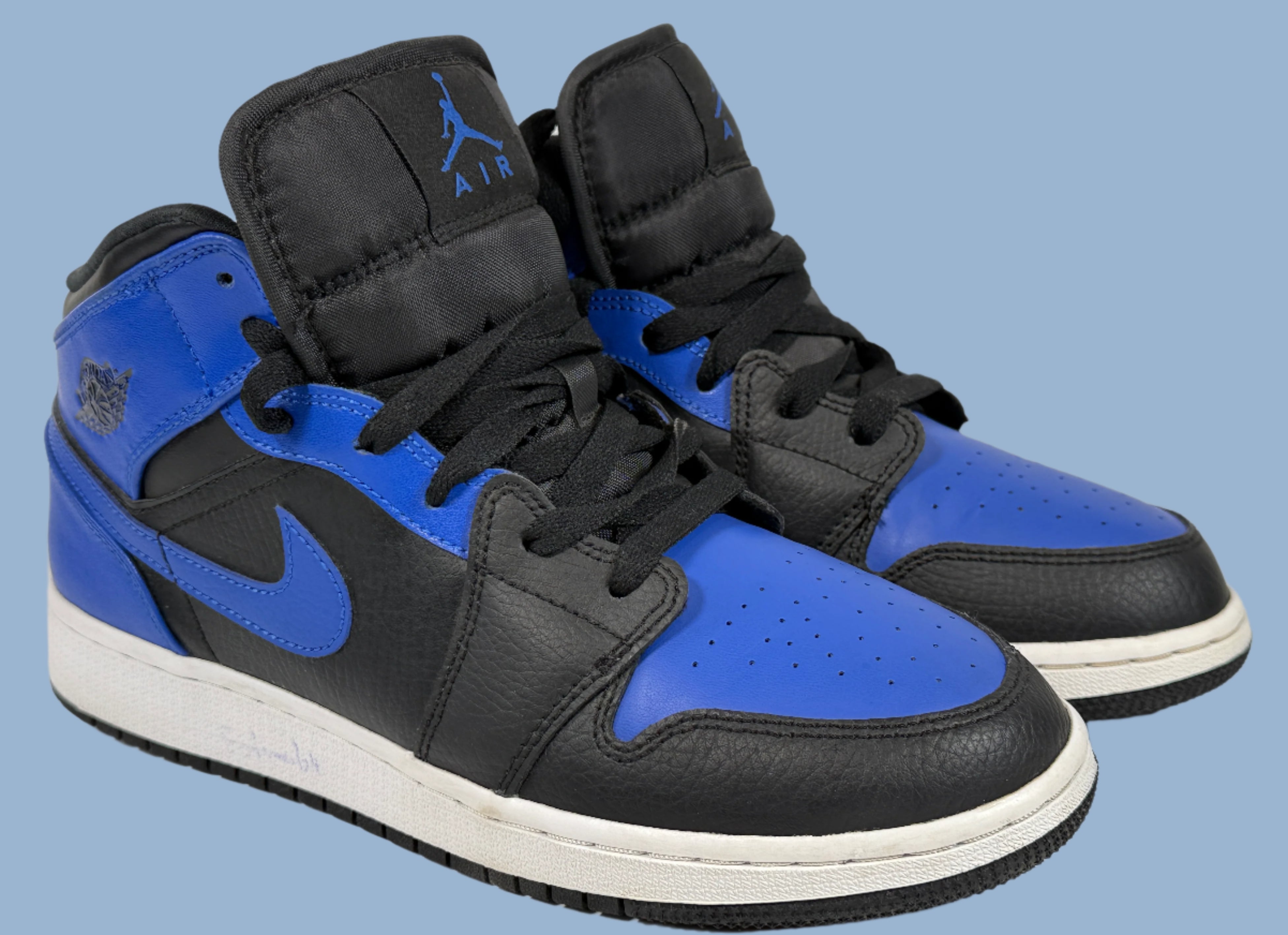 Black and blue high-top sneakers with a brand logo on a light gray background
