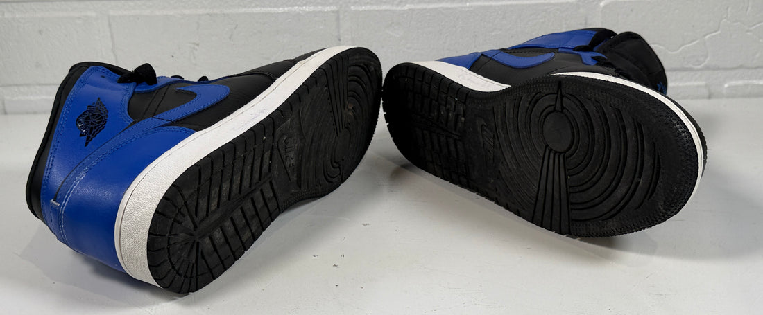 Blue and black high-top sneakers on a white floor with a light gray wall background