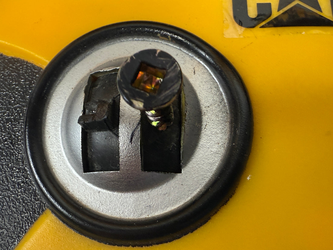 Close-up of a mechanical component on a yellow background with 'CAT' branding.