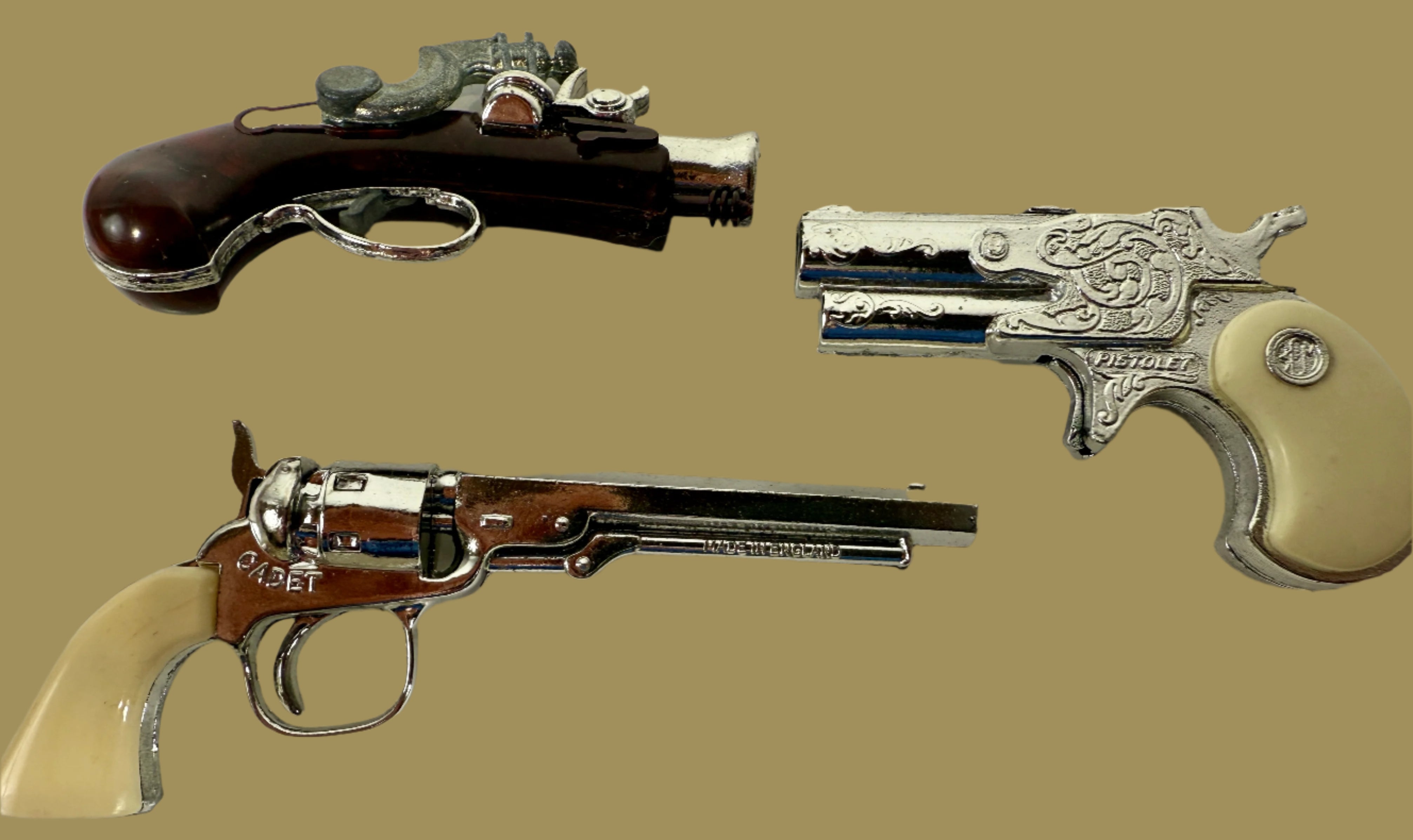 Three toy guns on a light gray background