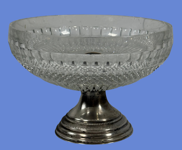 Decorative glass bowl with metal base on a white surface