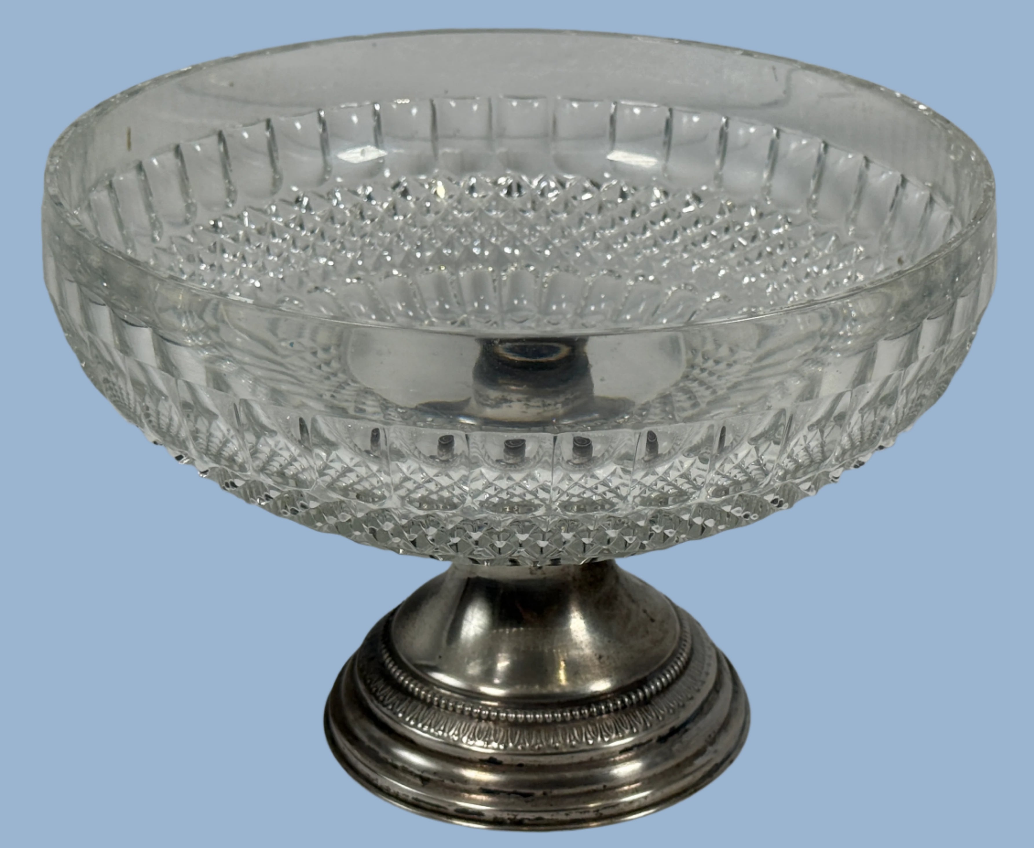Decorative glass bowl with silver base on a white background
