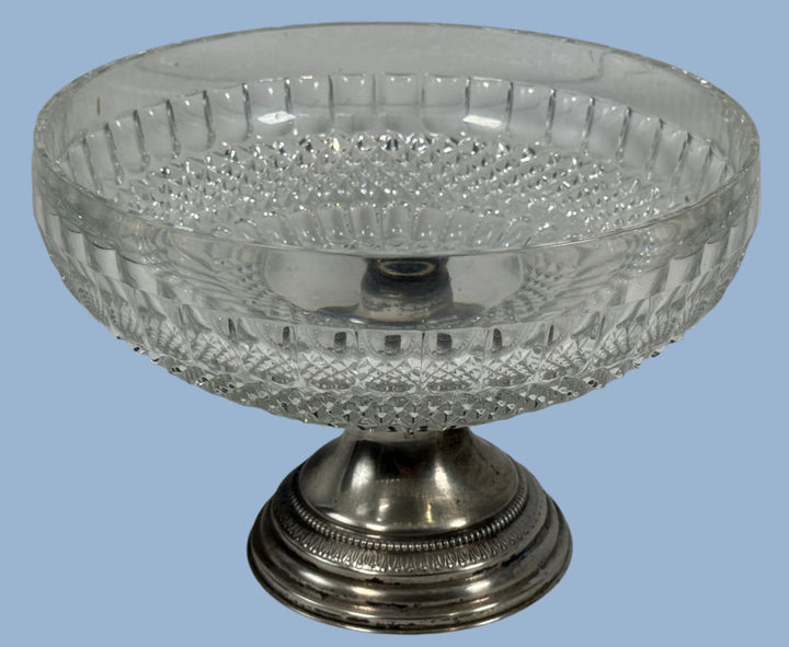 Decorative glass bowl with silver base on a white background