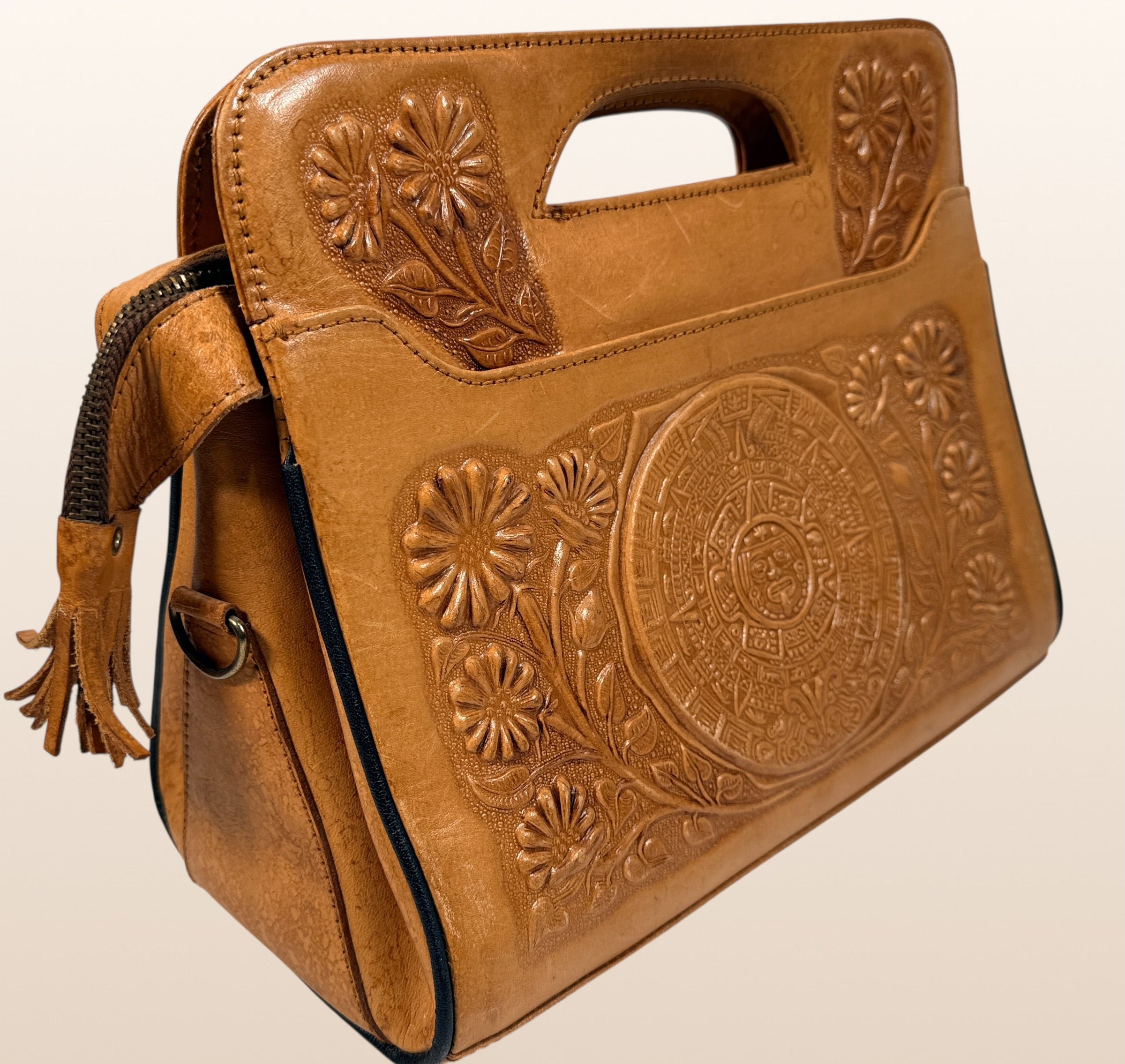 Vintage Mexican tooled leather handbag with Aztec calendar motif, floral embossing, detachable strap, classic artisan leather purse with strong vintage appeal.