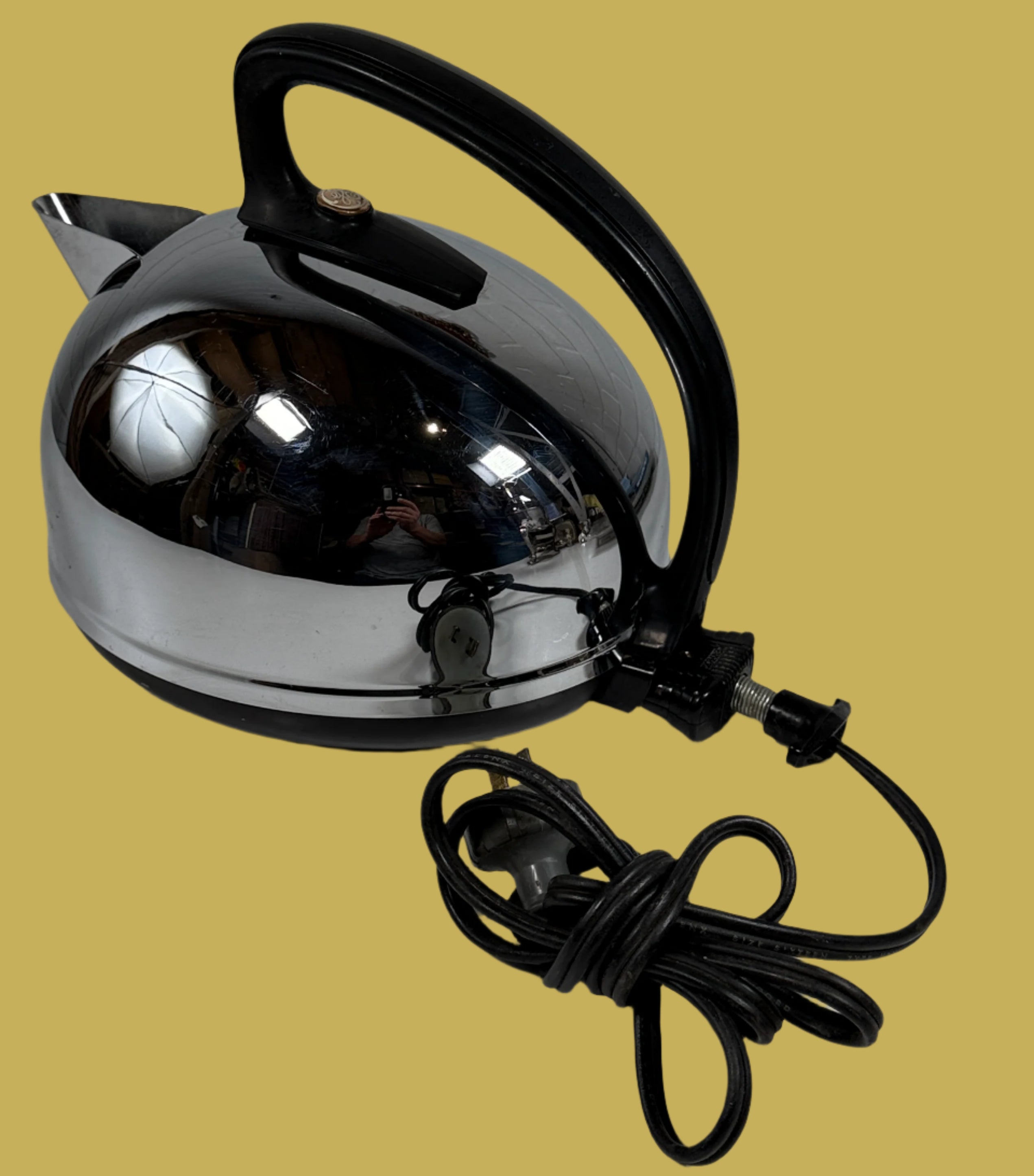 Chrome electric kettle with black handle on a white surface