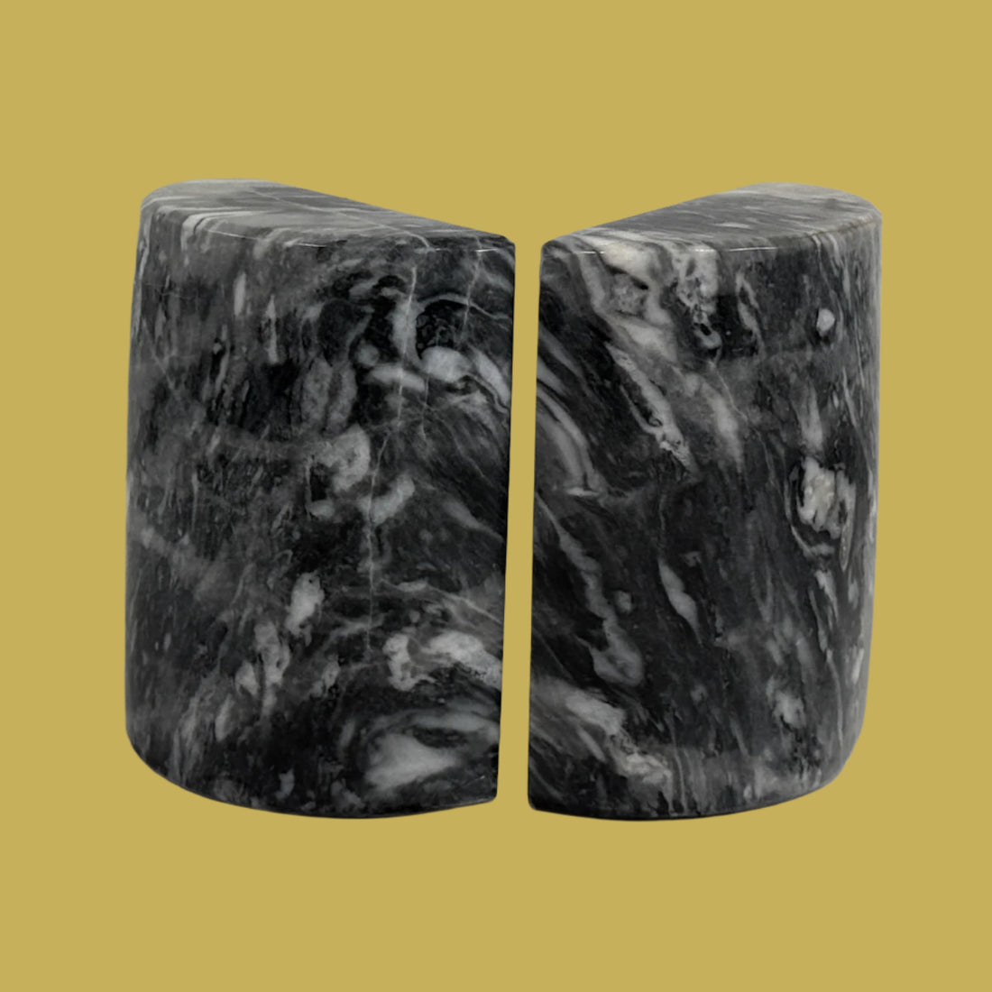 Marble-patterned bookends on a white surface with a light gray brick wall background