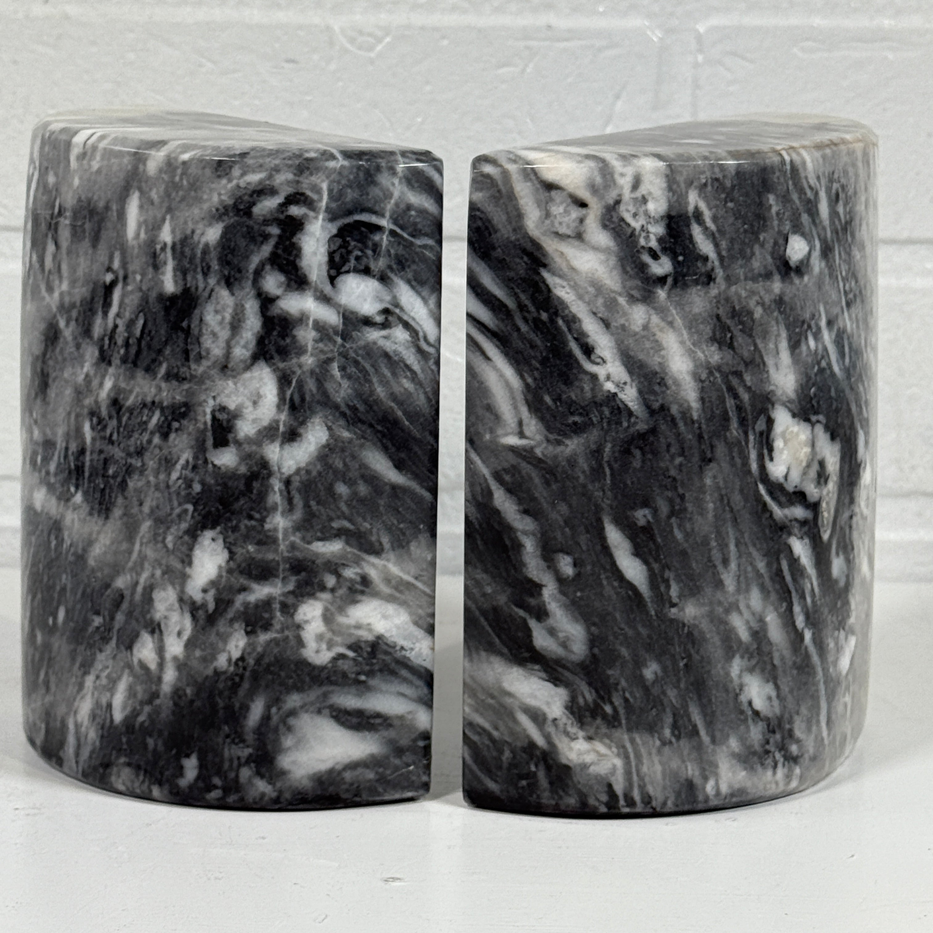 Two black and gray marbled objects on a white background