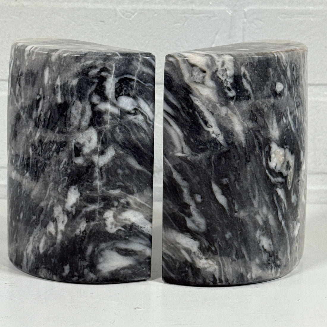 Two black and gray marbled objects on a white background