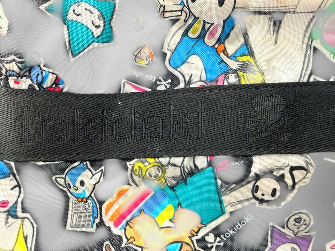 Tokidoki graphic nylon shoulder bag with character print, pink lining and charm. Designer streetwear purse in great condition, collectible fashion accessory.