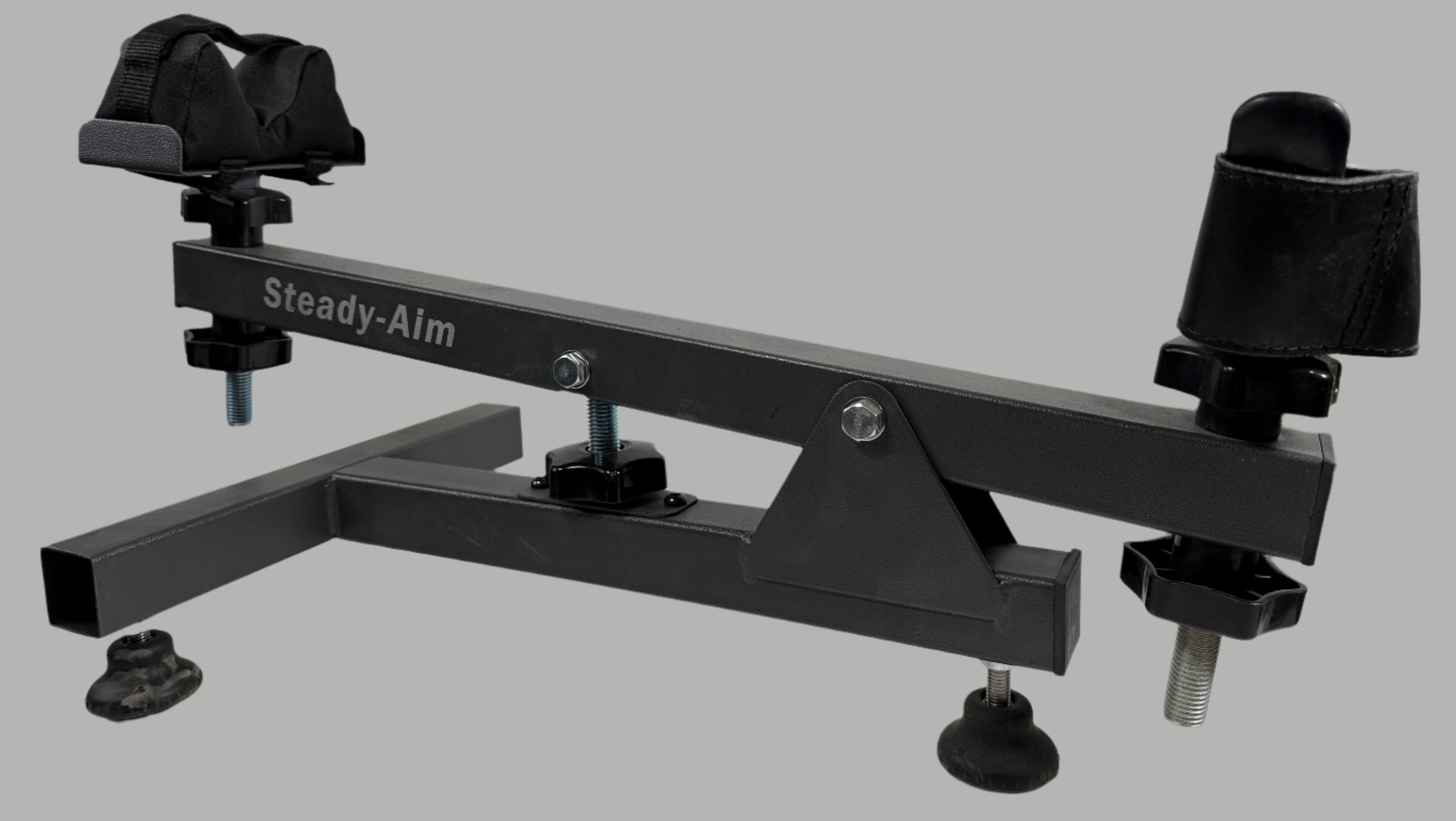 Black Steady-Aim device on a white surface with a white brick wall background