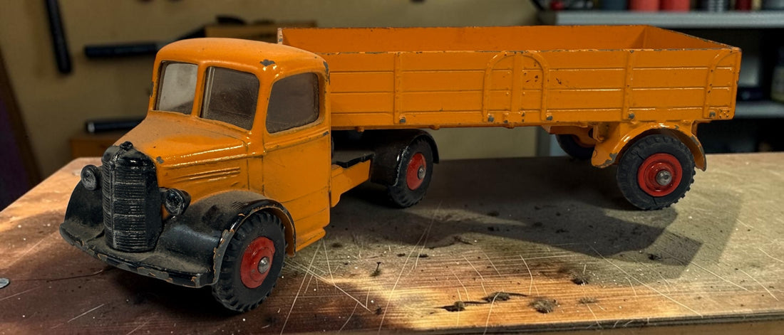 Vintage Dinky Toys Bedford articulated lorry by Meccano Ltd., England. Original die-cast truck and trailer in orange with classic red wheels.