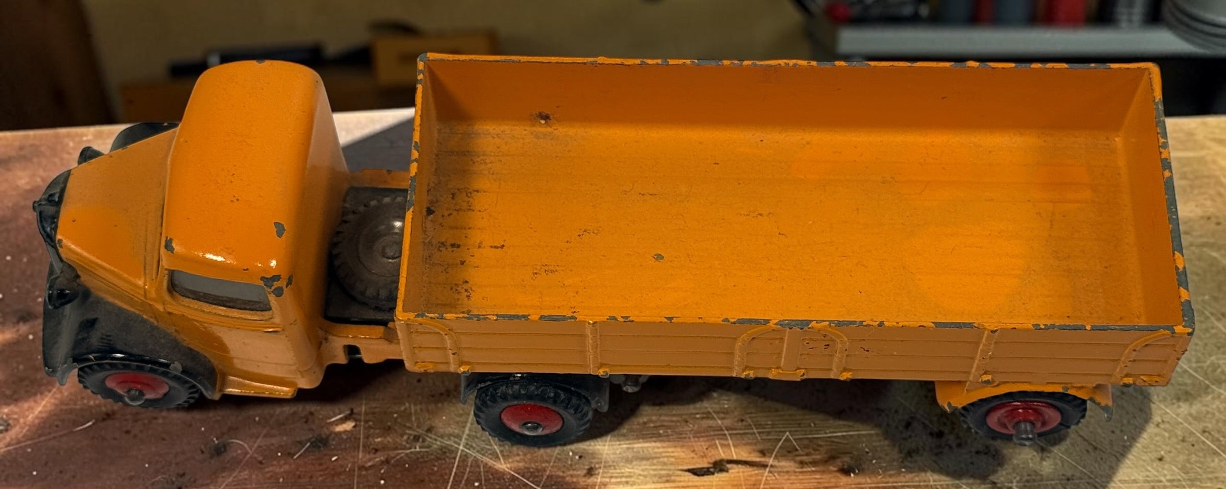 Vintage Dinky Toys Bedford articulated lorry by Meccano Ltd., England. Original die-cast truck and trailer in orange with classic red wheels.