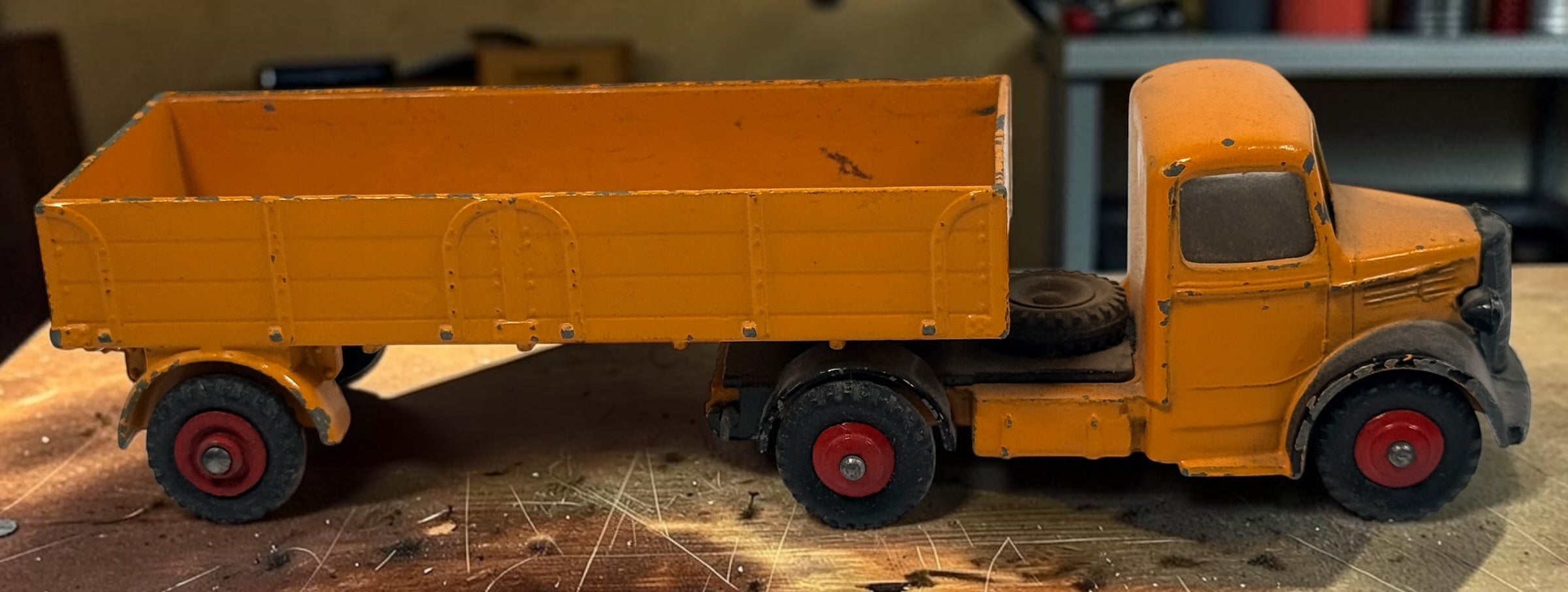 Vintage Dinky Toys Bedford articulated lorry by Meccano Ltd., England. Original die-cast truck and trailer in orange with classic red wheels.