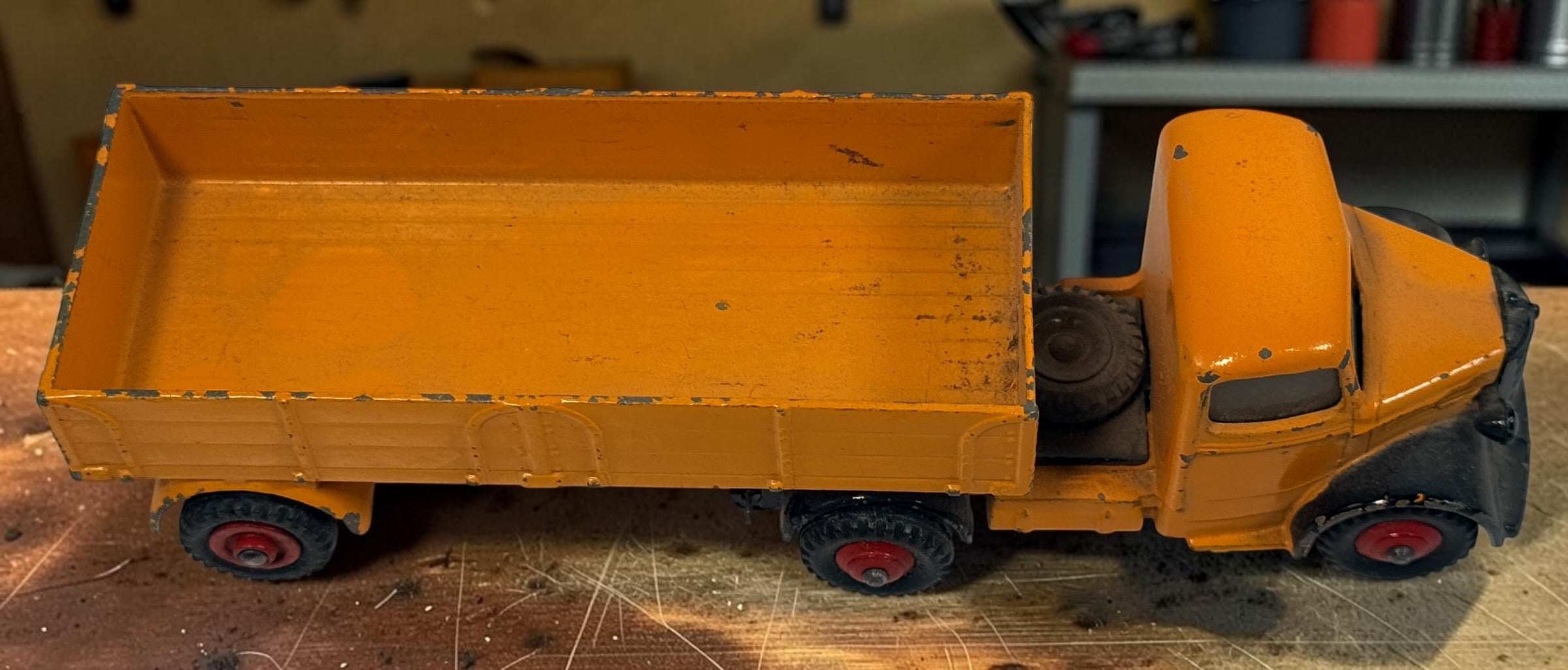 Vintage Dinky Toys Bedford articulated lorry by Meccano Ltd., England. Original die-cast truck and trailer in orange with classic red wheels.