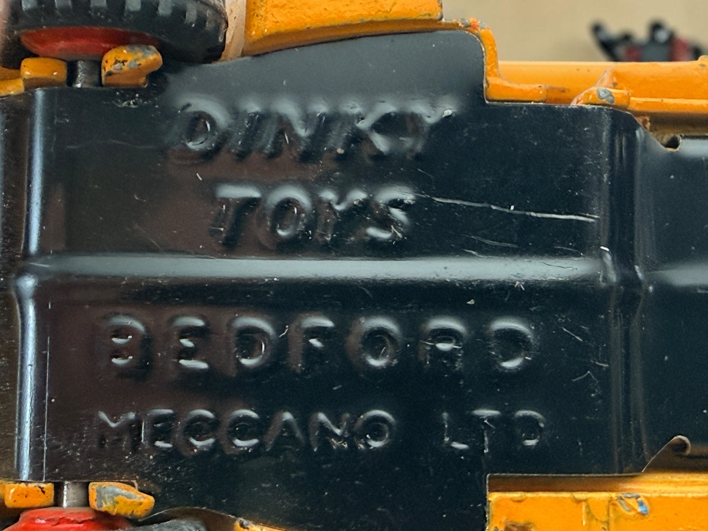 Vintage Dinky Toys Bedford articulated lorry by Meccano Ltd., England. Original die-cast truck and trailer in orange with classic red wheels.