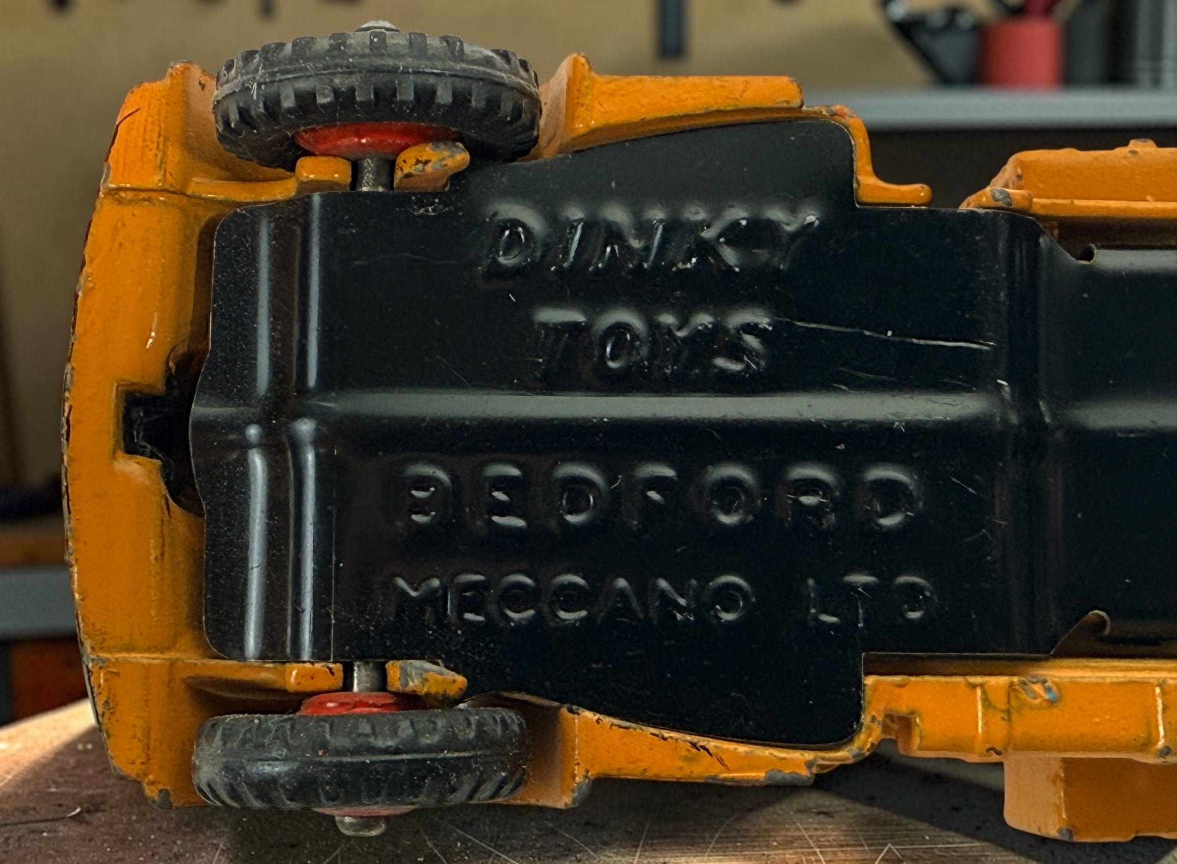 Vintage Dinky Toys Bedford articulated lorry by Meccano Ltd., England. Original die-cast truck and trailer in orange with classic red wheels.