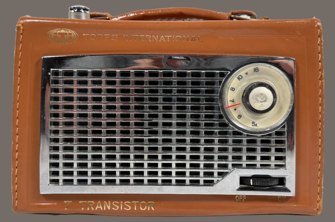 Vintage brown transistor radio with metallic grille and dial on a white background