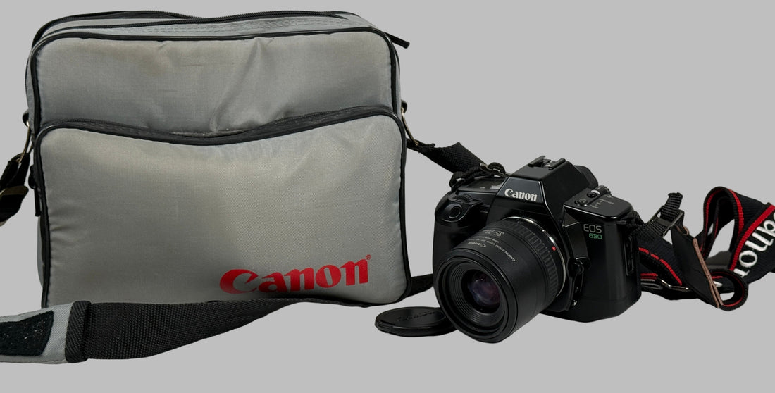 Canon camera and bag on a white surface with a light gray brick wall background