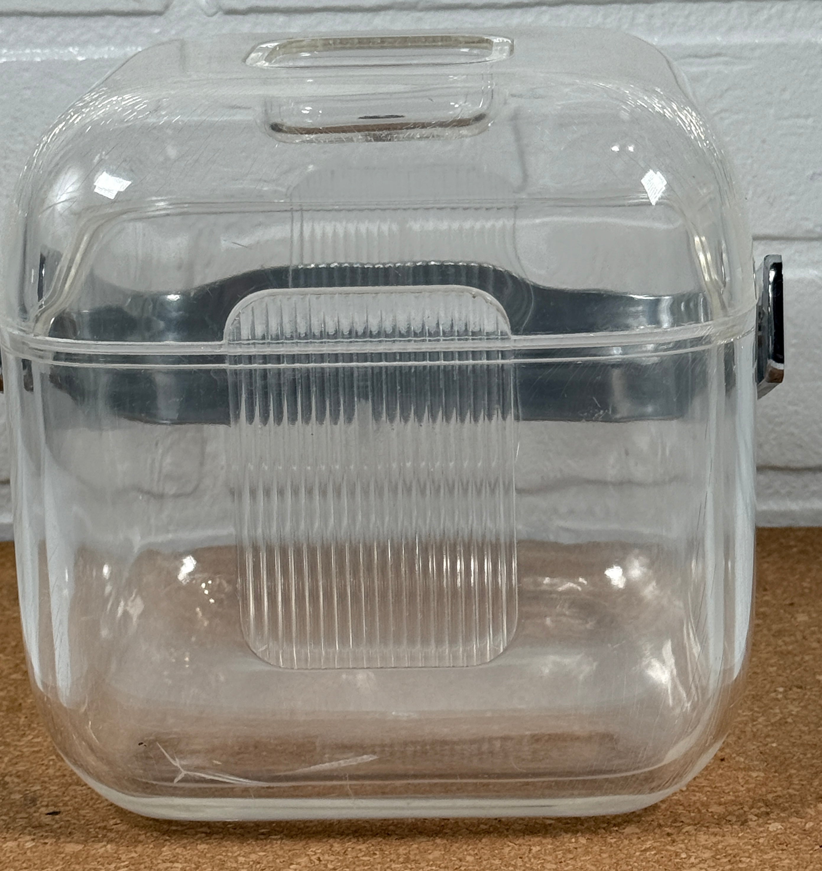 Clear plastic container with a lid on a wooden surface