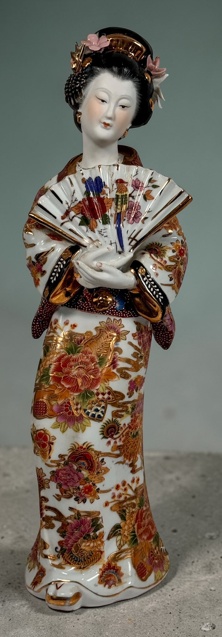 Vintage Japanese porcelain geisha figurine with hand-painted florals and raised gilt moriage detail. Elegant mid-century decorative display piece
